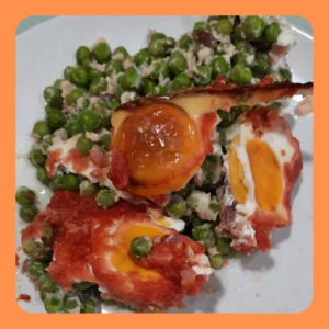 Huevos escalfados al horno con guisantes, tomate y jamón